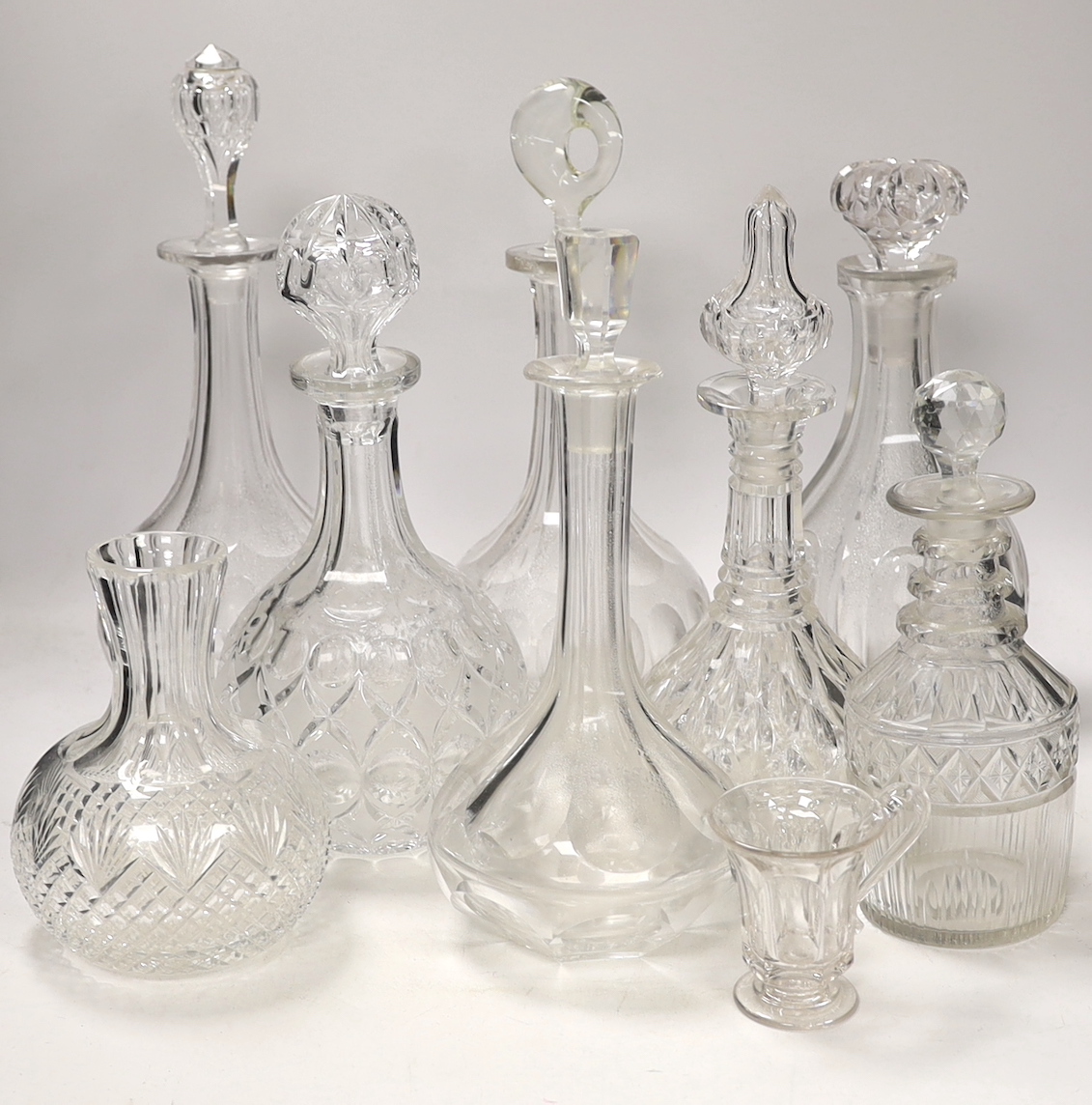 Seven decanters, all with stoppers, a carafe, a custard cup, tallest, decanter 34cm